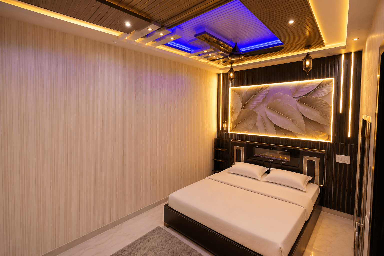 Modern bedroom with a backlit false ceiling and illuminated wall panel